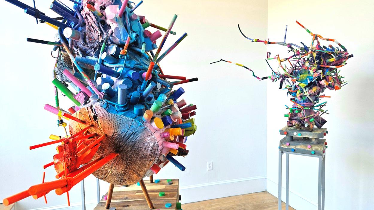Photo of two sculptures by Lee Williams displayed in a gallery composed of wood and colorful materials