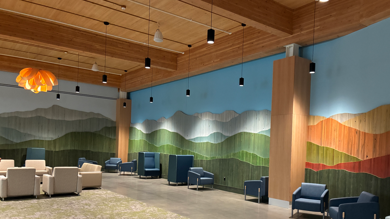 a photo of an at installation Vert Mont by Ben Butler that is comprised of painted reclaimed boards that are assembled to depict the green mountains