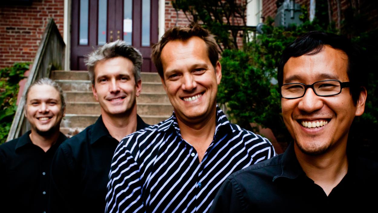 Members of Trio Gusto pose together in front of a residence