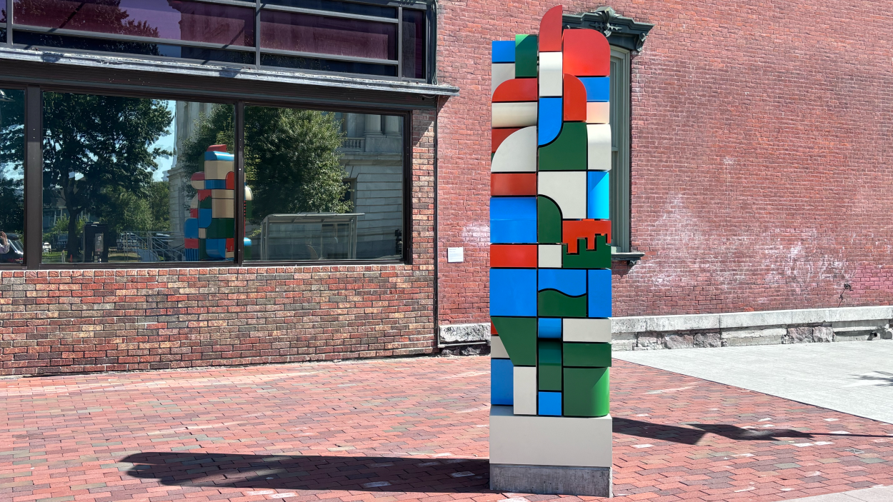 a photograph of Block by Block, a sculpture composed of multicolored blocks in a tower form